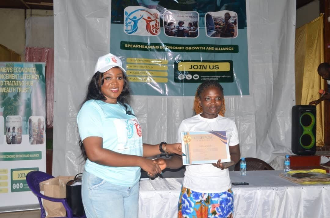 A Wealth Trust facilitator presenting a certificate to a young woman