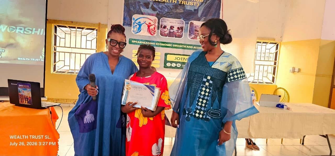A woman holding her certificate between two facilitators