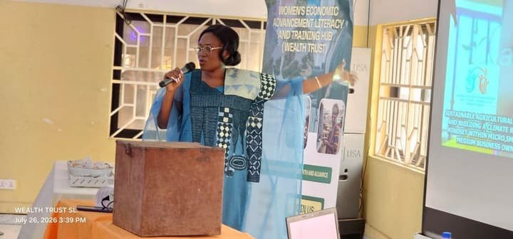 A facilitator speaking beside a savings box